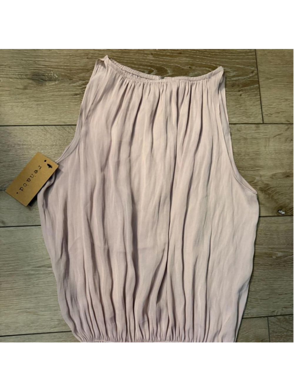 Dusty blush sleeveless blouse with a wide smocked waist and flowy silhouette.